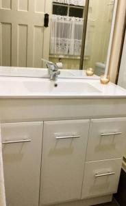 a bathroom with a white sink and a mirror at Amiens Cottage, historic, quiet, in heart of Stanthorpe in Stanthorpe +40 photos