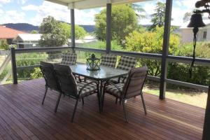 a table and chairs on a deck with a view at Amiens Cottage, historic, quiet, in heart of Stanthorpe in Stanthorpe