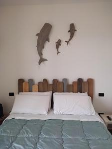 una camera da letto con un letto con due delfini sul muro di VENTO DI BOLINA a Giovinazzo Altre 28 foto