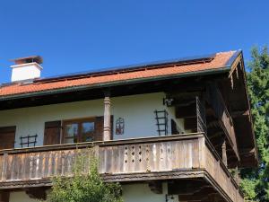 a house with a balcony and a roof at Ferienwohnung Sonnenläng in Hechenberg