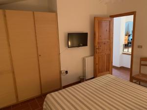 - une chambre avec un lit et une télévision murale dans l'établissement B&B Codivilla, à Sasso Marconi