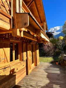 un edificio de madera con una pasarela de madera delante de él en Chalet massif du Mont Blanc St Gervais Megeve, en Saint-Gervais-les-Bains