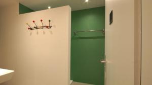uma casa de banho com um chuveiro e uma parede verde em Alte Metzg - Hostel em Appenzell