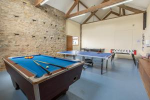 a room with two pool tables and a brick wall at Carnedd Cottage in Dwyran