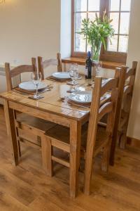 una mesa de madera con platos y vasos. en Carnedd Cottage, en Dwyran 22 fotos más