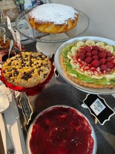 uma mesa coberta com tartes e sobremesas em pratos em La terrazza sulle vigne B&B em Corte Franca