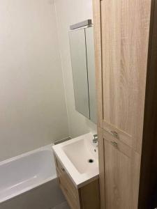 een witte badkamer met een wastafel en een spiegel bij 't Genot in Blankenberge