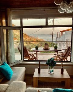 a living room with a table and a large window at Harmony Family house in Kerames