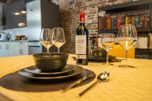 a table with a bottle of wine and three wine glasses at L'atelier de Liège: Tranquillité & Effervescence in Liège