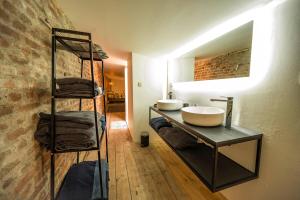 uma casa de banho com dois lavatórios num balcão e uma parede de tijolos em L'atelier de Liège: Tranquillité & Effervescence em Liège