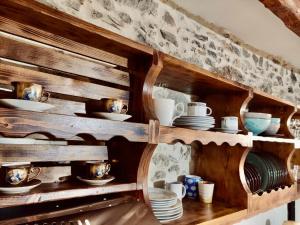 une étagère en bois avec des tasses et de la vaisselle dans l'établissement Harmony Family house, à Kerames