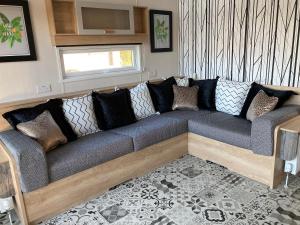 a couch in a living room with a window at Chapel Fields Holiday Park in Chapel Saint Leonards