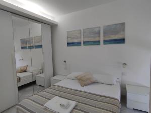 サンタ・マリネッラにあるCasa del Mareの白いベッドルーム(ベッド1台、鏡付)