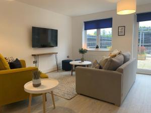 uma sala de estar com um sofá e duas mesas em Stylish & Spacious 3 Bed House With 2 Free Car Parking Spaces em Appledram