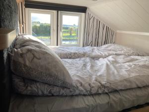 a bed sitting in a room with two windows at Chapel Fields Holiday Park in Chapel Saint Leonards