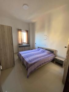 普若佛的住宿－St Orsola Apartments，一间卧室配有一张紫色床和窗户
