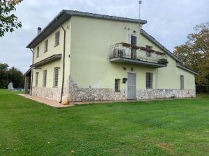 Casa blanca grande con balcón y patio en Splendida villa con piscina, en Vignanello