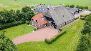 une vue aérienne sur une grande maison avec un toit orange dans l'établissement Vakantiehuis Bij Vermeer, à Een