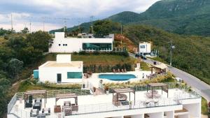 a house on top of a hill with a pool at MIRANTE DE ESCARPAS 1704 in Capitólio