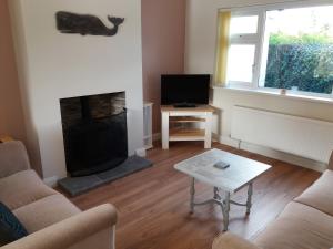 sala de estar con chimenea y TV en Lough Conn Holiday Home, en Crossmolina