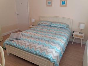 a bed with a colorful comforter in a bedroom at Lough Conn Holiday Home in Crossmolina