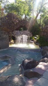 una cascada en una piscina con rocas en un patio en La casa de Tea, en Santa Lucía