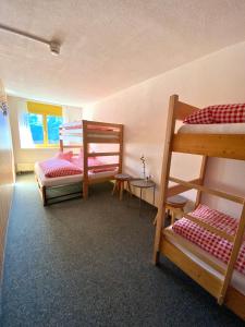 a room with three bunk beds and a table at Berggasthaus First - Only Accessible by Cable Car in Grindelwald