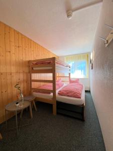 a small bedroom with a bunk bed and a table at Berggasthaus First in Grindelwald