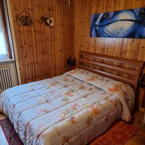 una camera con un letto su una parete in legno di Appartamento Maggio di fronte palaghiaccio ad Aosta