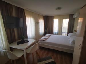 a hotel room with a large bed and a television at DAMARIS in Sozopol