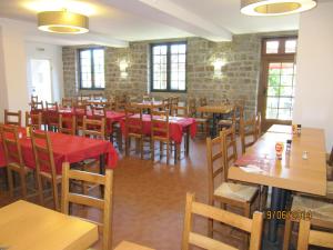 a dining room with wooden tables and chairs at Auberge Le Guinefort in Léhon