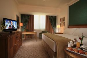 a hotel room with a bed, tv and a desk at Sonesta Hotel Tower & Casino Cairo in Cairo