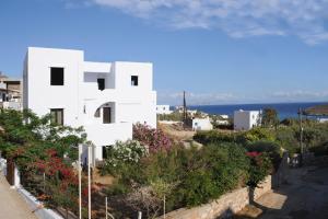 a white building on a hill next to the ocean at Lygaria in Agios Ioannis