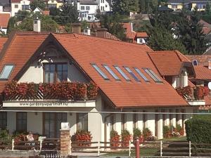 ein Haus mit rotem Dach mit Blumenkästen drauf in der Unterkunft Gárdonyi Apartman in Eger