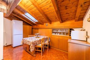 una cucina con tavolo e frigorifero di Tizzi Home ad Alleghe
