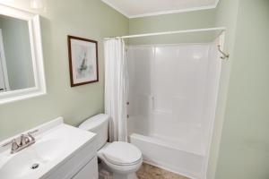 un bagno bianco con doccia e WC di 2BR, 2Bath condo Oceanfront Getaway with pool a Myrtle Beach