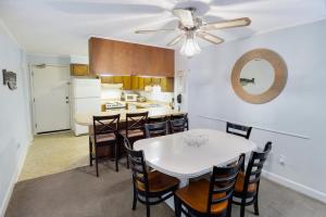 a kitchen and dining room with a white table and chairs at 2BR, 2Bath condo Oceanfront Getaway with pool in Myrtle Beach