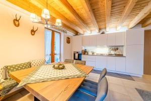 cocina y comedor con mesa de madera y sillas en Charming Civetta en Alleghe