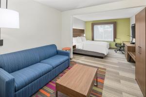 um quarto de hotel com um sofá e uma cama em Holiday Inn Express Hotel & Suites Palm Bay, an IHG Hotel em Palm Bay