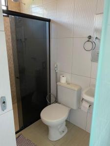 a small bathroom with a toilet and a shower at Flat no Caribe in Maragogi