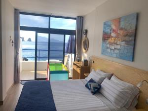 - une chambre avec un lit et une vue sur l'océan dans l'établissement Touch the Sea, à Sardina