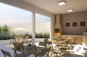 a dining room with tables and chairs and a fireplace at Quarto e sala piscina aquecida in Brasília
