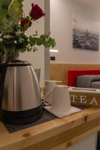 a table with a vase of flowers and a tea pot at B&B Le Nazioni in Lido delle Nazioni