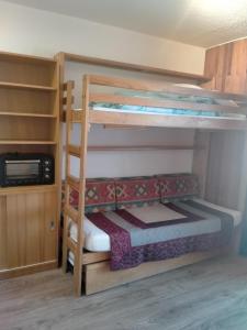 a bunk bed room with two bunk beds and a microwave at Studio Champerouze 127 in La Toussuire