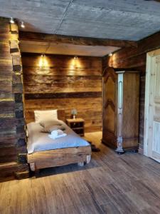 NarewkaにあるBojarski Gościniecの木製の壁のベッドルーム1室(ベッド1台付)