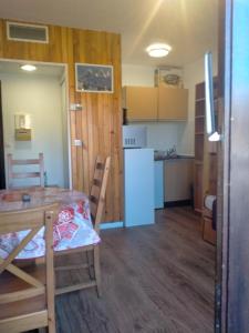 Una cocina y un comedor con mesa y sillas. en Studio Champerouze 127, en La Toussuire