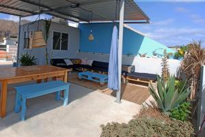 a patio with a table and blue benches and a table at Cloud7 Beach Hostel in Tarrafal