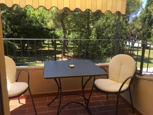 Il Colle delle Terrazze في فانو: كرسيين وطاولة على شرفة مع طاولة وكراسي