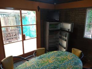 a dining room with a table with chairs and a window at El Gringo Tito in La Falda