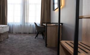 
a room with a bed, chair and a window at JOYME Hotel in Sibiu

